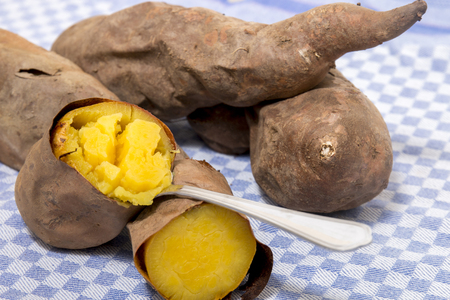 Cooked oven sweet potatoes on a table cloth fabric.の写真素材