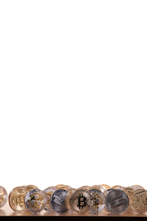 several aligned crypto currency coins on top of wooden table.の写真素材