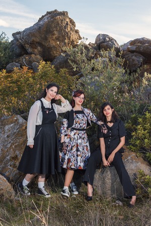 Group of three girls posing in nature with vintage clothing.