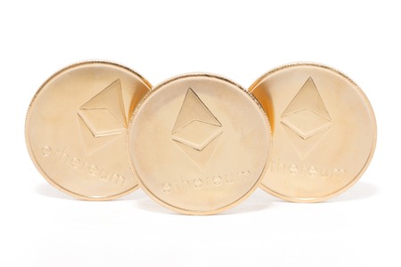 Shiny golden ethereum coins over a white background.