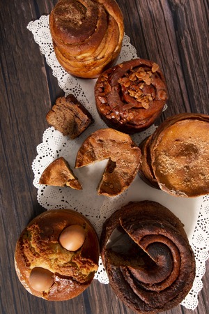Mix of famous Portuguese folar cakes on a wooden background.