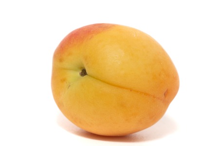 View of a tasty Armenian plum (Prunus armeniaca) over a white wooden background.の写真素材