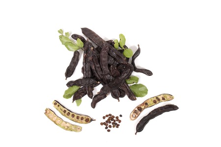 carob fruits with leafs isolated over a white background.