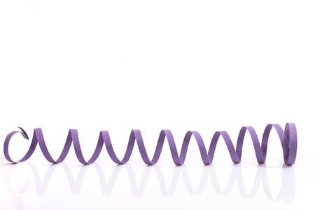 Purple streamer serpentine on a white background.の写真素材