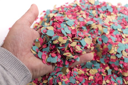 Hand grabs a mix of colorful confetti.