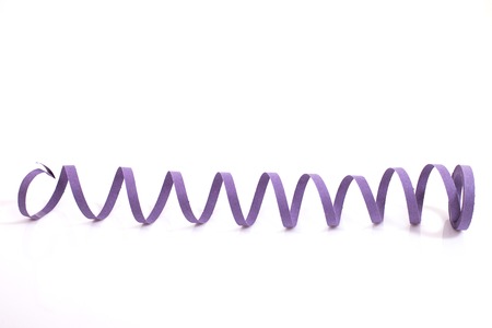 Purple streamer serpentine on a white background.の写真素材