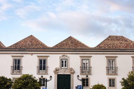 typical portuguese rooftops with red tiles, chimneys painted with white.の写真素材