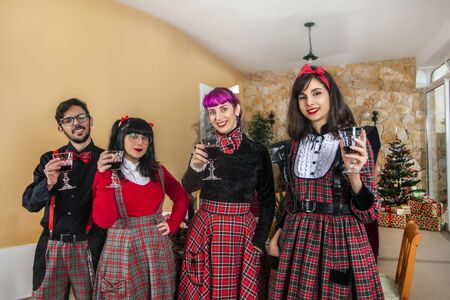 group of friends at christmas table celebrating with wine.の写真素材