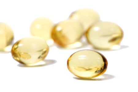 Close up view of translucid yellow pills isolated on a white background.の写真素材