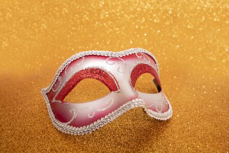 View of a carnival venetian mask on a golden background.の写真素材