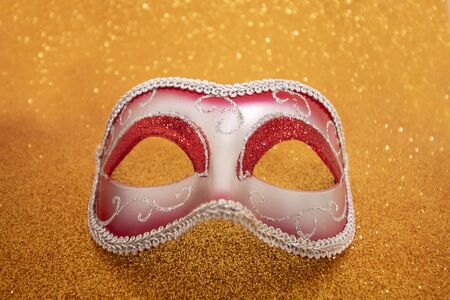 View of a carnival venetian mask on a golden background.の写真素材