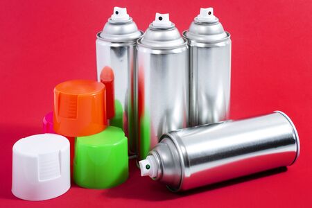 Close up view of silver spray cans on a red background.の写真素材