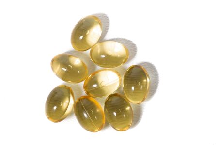 Close up view of translucid yellow pills isolated on a white background.の写真素材