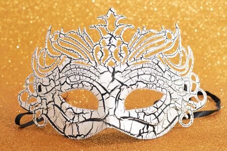 View of a carnival venetian mask on a golden background.の写真素材