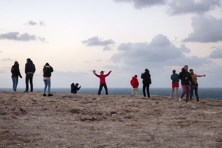 SAGRES, PORTUGAL: 28th of October, 2018 - People being playful on the strong winds of the coastline of Sagres, taking photos and resisting the winds.のeditorial素材