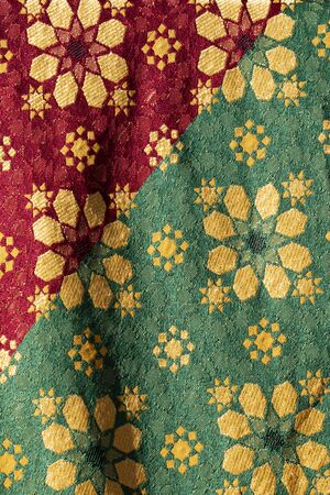 Close up view of Traditional  red, green and golden medieval fabric design.