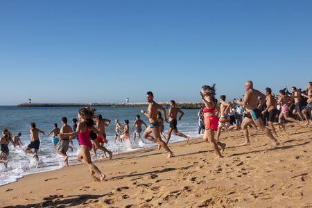 QUARTEIRA, PORTUGAL: 1st JANUARY, 2020 - People of all ages gather to an event for the first dive/plunge of the new year into the ocean water.のeditorial素材