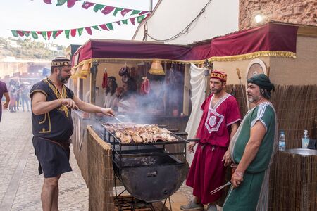 SILVES, PORTUGAL - August 11th, 2019 : Food court area of  Medieval festival where people eat grilled meat and other medieval meals.のeditorial素材