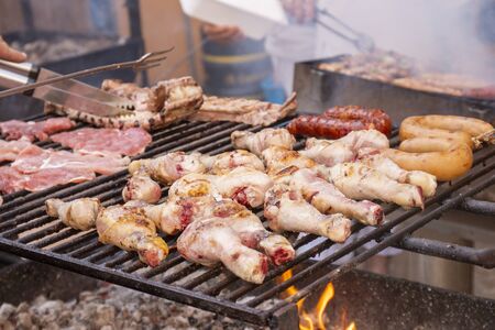 Mixed qualities of meat being grilled on charcoal.のeditorial素材