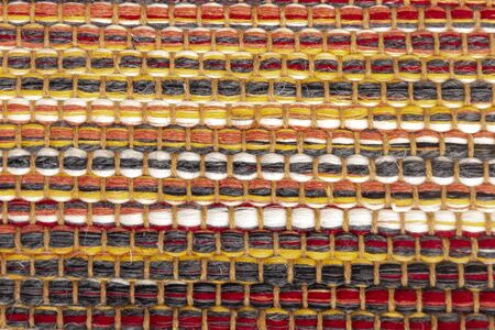 Close view texture of rug carpet in yellow, red and oranges tones.