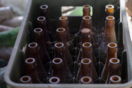 View of a bunch of abandoned beer and soda bottles on a barn.