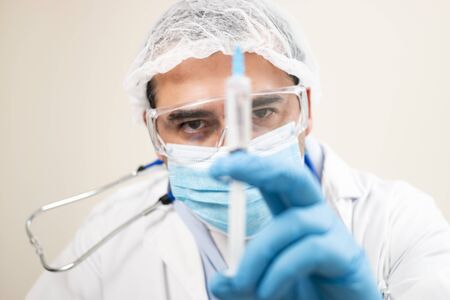 View of caucasian doctor with  syringe on a soft focus background.