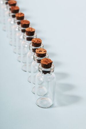 Glass bottles with cork isolated on a light blue background.の写真素材
