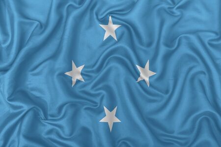 Federated States of Micronesia flag on wavy silk textile fabric background.の写真素材
