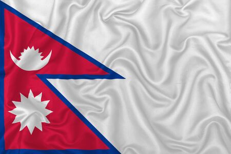 Federal Democratic Republic of Nepal country flag on wavy silk textile fabric background.の写真素材