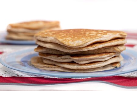simple american style fluffy pancakes stacked on a pile.