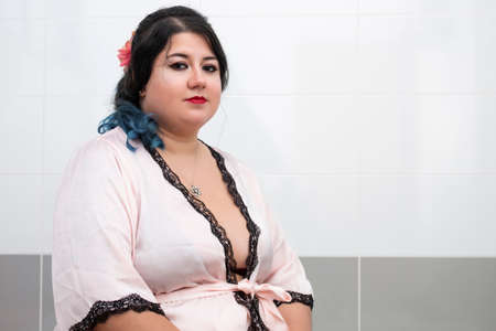 woman in sensual pink bathrobe and lingerie on the bathtub.の写真素材