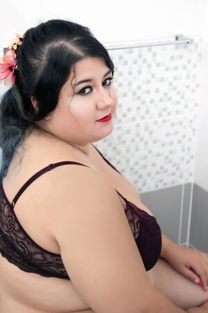 woman in sensual dark red lingerie on a milky bathtub.の写真素材