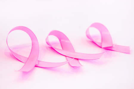 Three breast cancer awareness ribbons on a white background.の写真素材