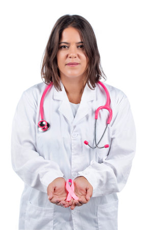 Close up view of female doctor hands holding pink breast cancer ribbon.の写真素材