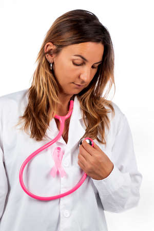 young beautiful doctor woman with pink stethoscope and pink awareness ribbon for breast cancer on a white background.の写真素材