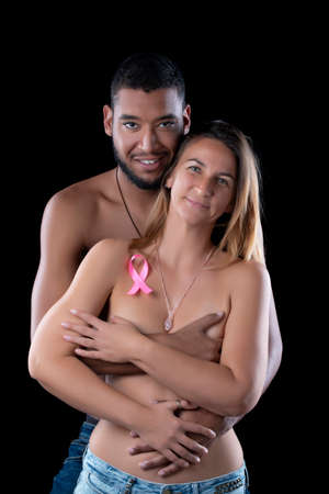 husband and wife hugging for breast cancer on a black background.の写真素材