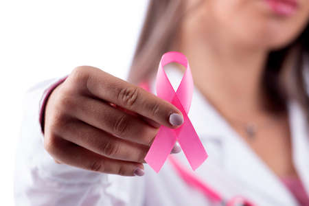 young beautiful doctor woman with pink stethoscope and pink awareness ribbon for breast cancer on a white background.の写真素材
