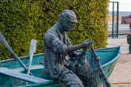 Close up view of a bronze fisherman statue, located in Olhao city, Portugal.の写真素材