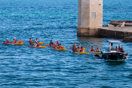 LAGOS, PORTUGAL - OCTOBER 23, 2021: Group of happy people on yellow kayaks doing sports.