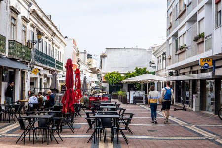 FARO, PORTUGAL - 27th MARCH 2022: Busy street in Faro with restaurants and several shops for tourists.のeditorial素材