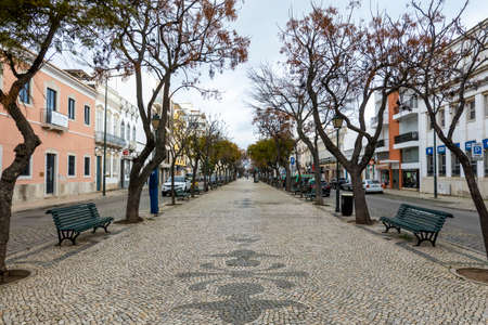 OLHAO, PORTUGAL - 13th FEBRUARY 2022: Long view of the Republic main avenue on Olhao city, with beautiful cobblestone artwork, Algarve, Portugal.のeditorial素材