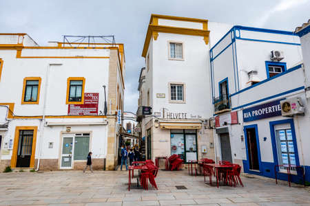 OLHAO, PORTUGAL - 13th FEBRUARY 2022: Typical architecture of Algarve rustic buildings with intricate designs of platbands and narrow cobblestone streets and small businesses.のeditorial素材