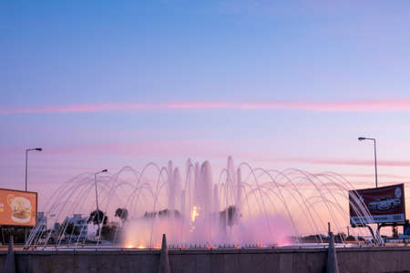 OLHAO, PORTUGAL - 15th FEBRUARY 2022: Water fountain on a roundabout at sunset located in Olhao city, Portugal.のeditorial素材
