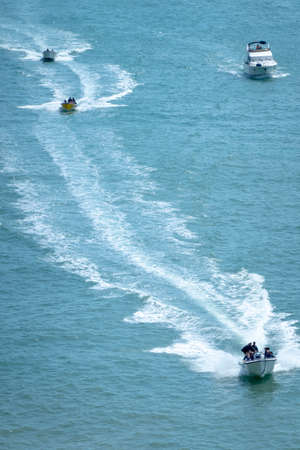 Tourists enjoying high speed boat near the cliffs of the Algarve region, Portugal.