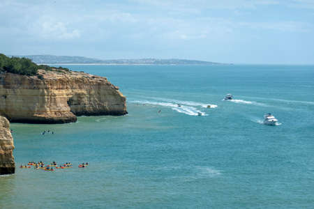 Group of people doing kayak near the beautiful cliffs of the Algarve region, Portugal.の写真素材