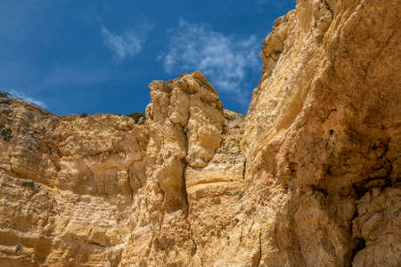 Natural sand formed by erosion of the elements located in the shoreline cliffs of the Algarve region, Portugal.の写真素材