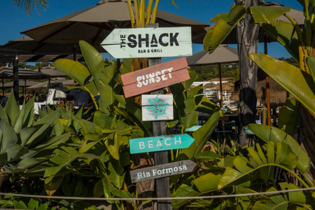 QUINTA DO LAGO, PORTUGAL - 26th JUNE 2022: Bar grill the Shack wooden post directions surrounded with palm trees on Quinta do Lago region located in the Algarve, Portugal.のeditorial素材
