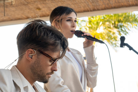 QUINTA DO LAGO, PORTUGAL - 26th JUNE 2022: Band duo singer and guitar player called Beatriz playing in a beach bar restaurant in Quinta do Lago.のeditorial素材