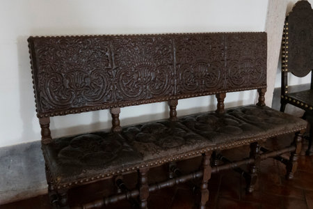 MAFRA, PORTUGAL - 29th JUNE 2022: Close up view of an ancient highly detailed dark wood bench.のeditorial素材