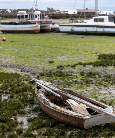 Abandoned fishing boat on the marshlands of Fuseta village, Portugal.の写真素材